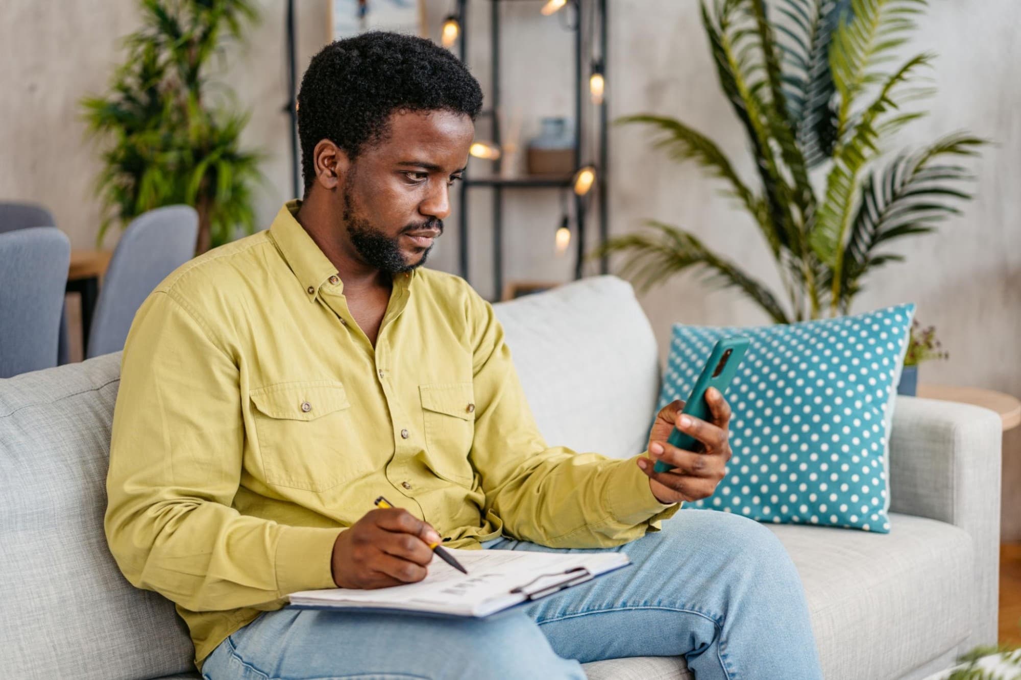 A young professional checking his phone while tracking everyday expenses